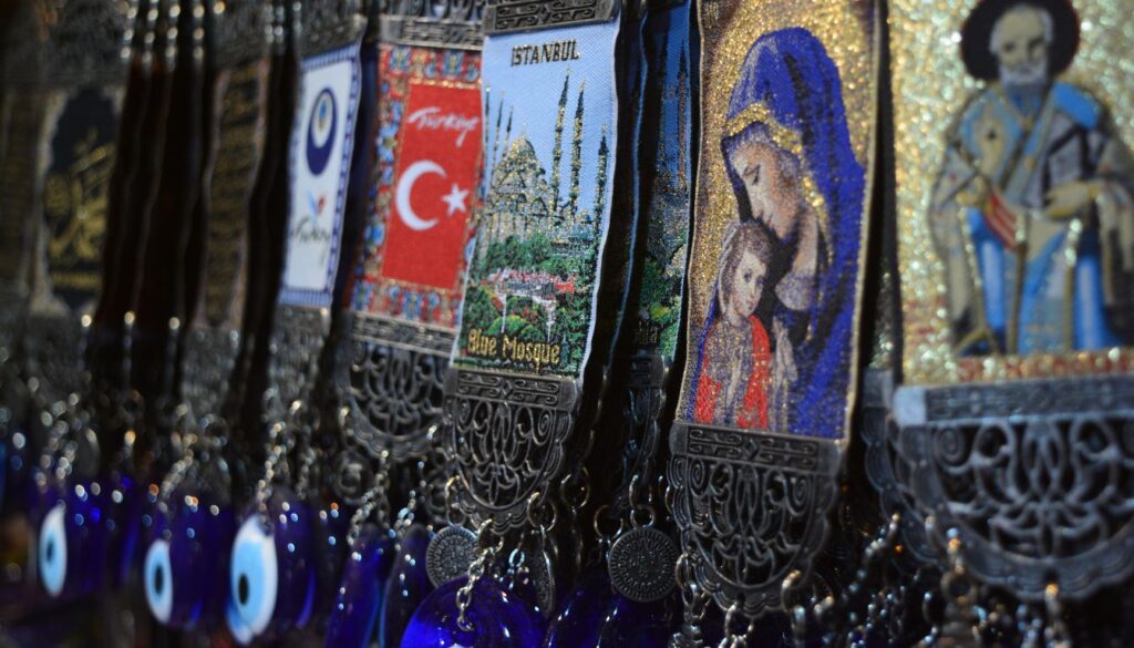 Traditional Turkish cultural elements, including a tea set, colorful ceramics, Turkish delight, and people in traditional attire during a cultural event.